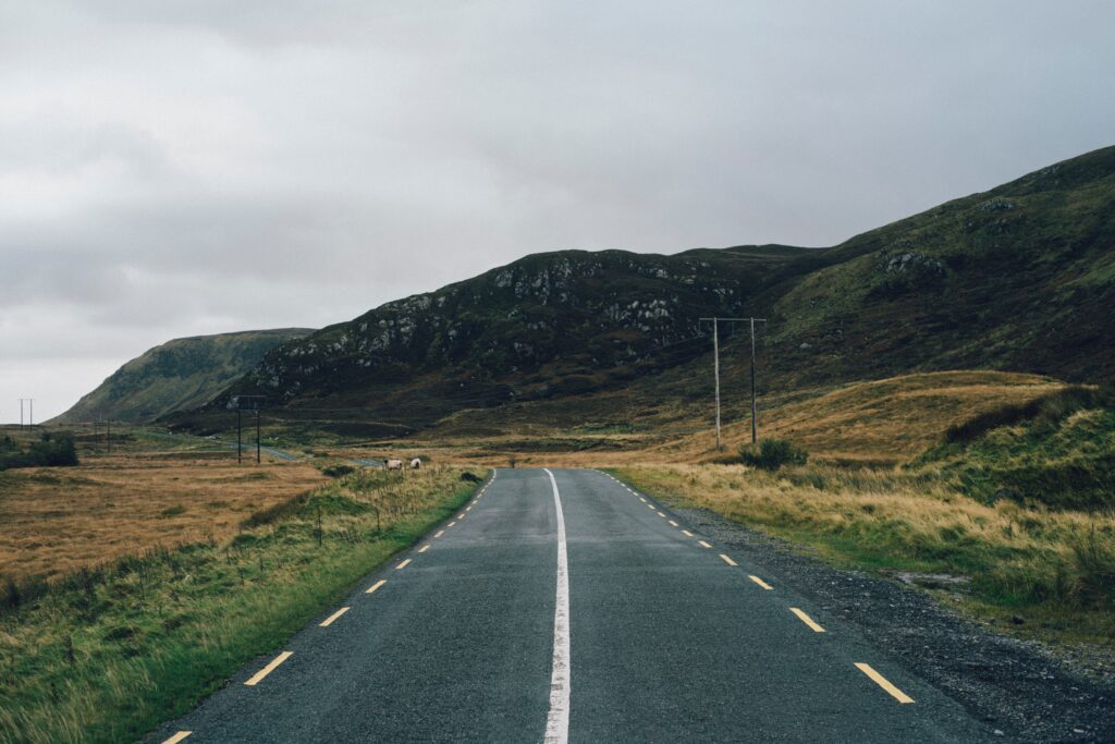 country road with grass and hills