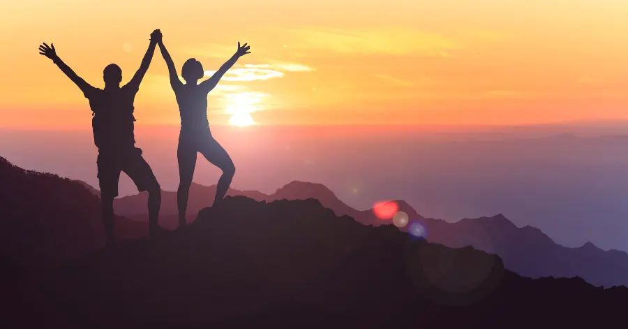 Summer bucket list ideas - people on top of a mountain at sunset