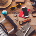 15 Must-Have Travel Essentials for Men You Shouldn’t Travel Without: phone, luggage, notebook, hat, sunglasses, key, phone