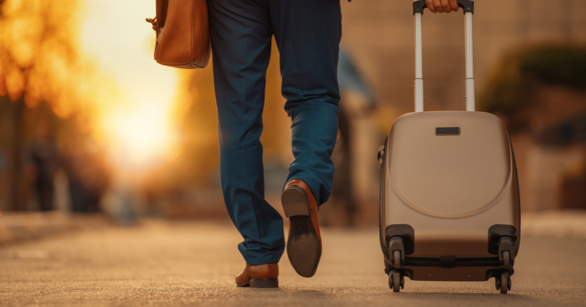 30 Must-Have Travel Accessories for Men - view of man walking with luggage