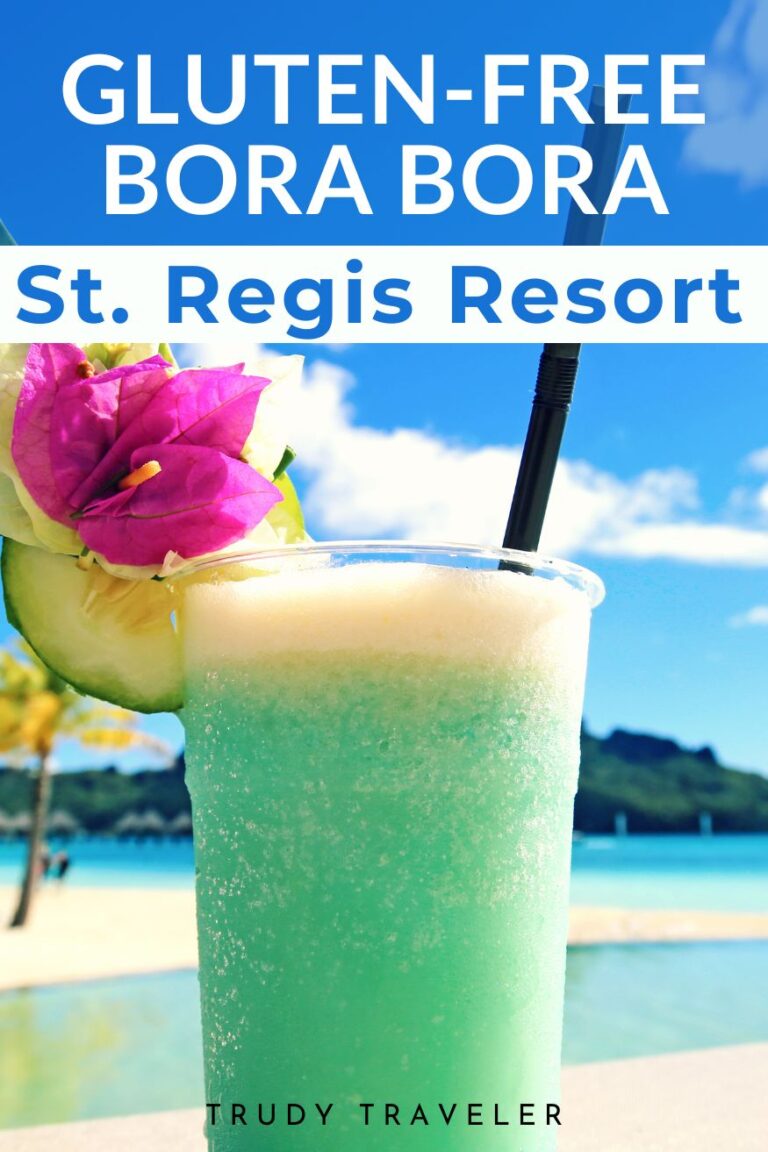 turquoise tropical drink with the beach and ocean behind it