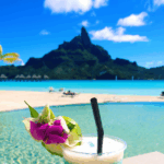 Tropical drink with a view of the beach, ocean and mountain behind it